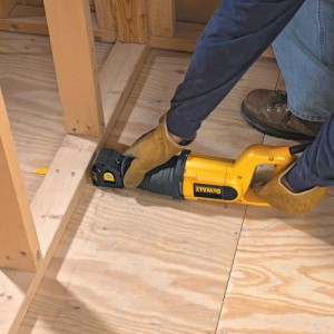 De dewalt dw304pk die een houten balk tot door de grond afzaagt.